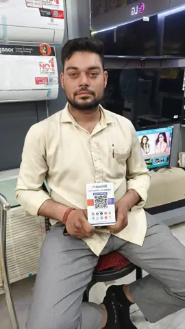 Electronics shop owner with his SaathiX QR code card